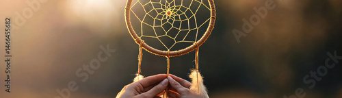 Obraz na płótnie Closeup hands holding handmade dreamcatcher with feathers, sunlight background, peaceful and creative atmosphere w salonie