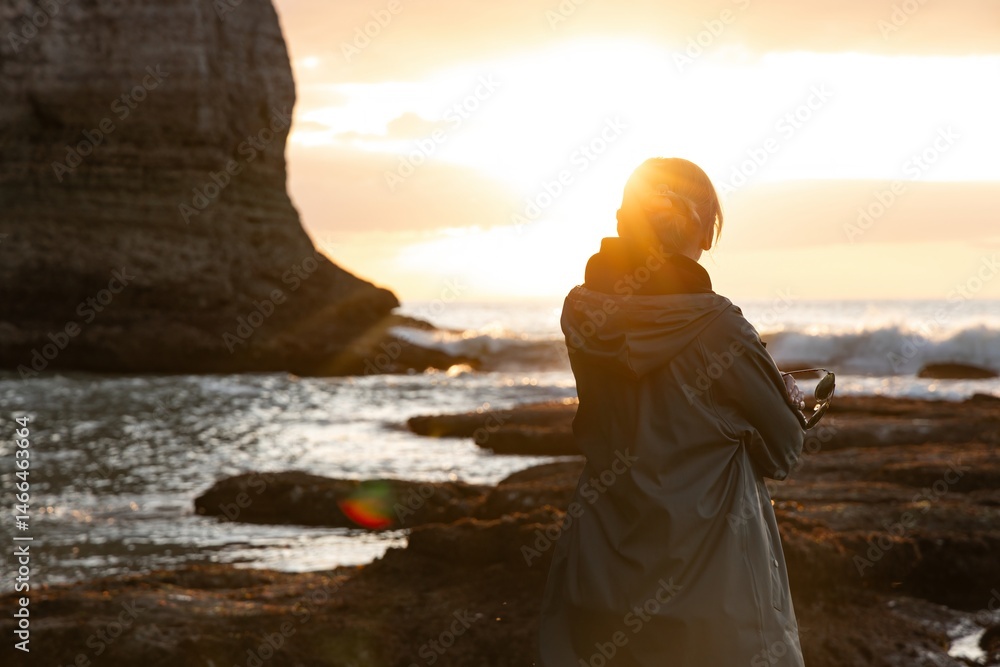 Serene Beach Sunset with Silhouetted FiguresTranquil scene of a person standing in the shallow water of a beach during sunset. Golden light reflects off the waves like a peaceful Serene Beach Sunset with Silhouetted FiguresTranquil scene of a person standing in the shallow water of a beach during sunset. Golden light reflects off the waves like a peaceful