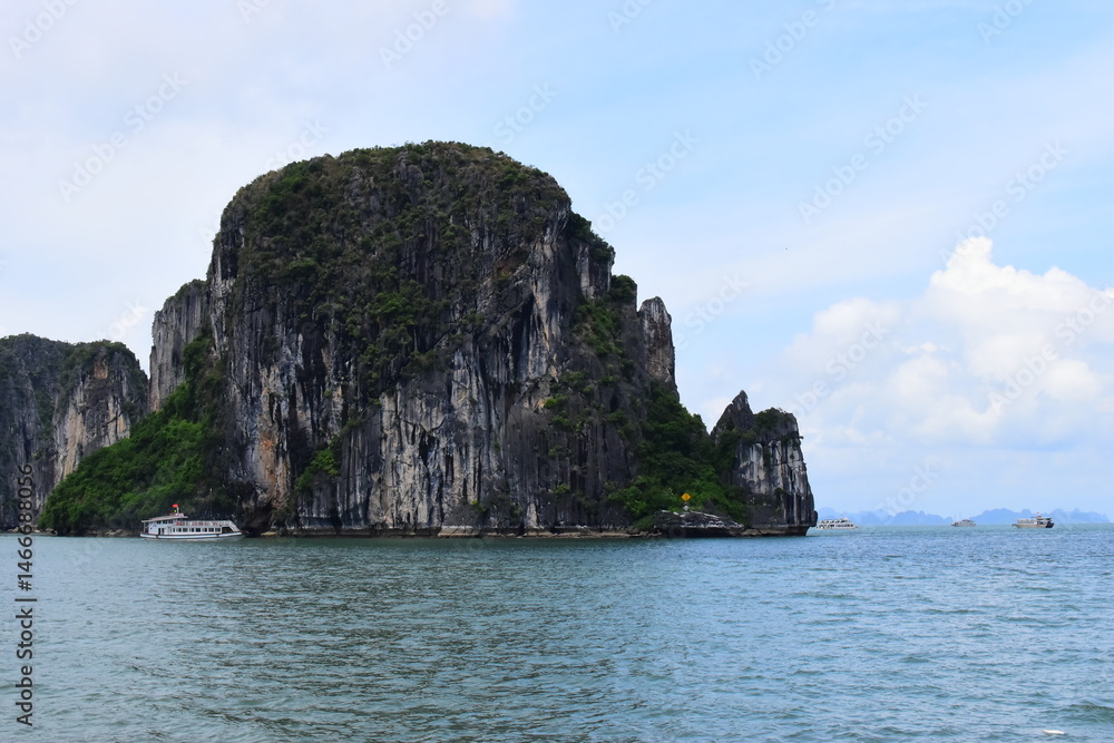 Fototapeta premium HA LONG BAY, VIETNAM - JULY 19, 2022: Beautiful view of the Halong bay, Vietnam. UNESCO World Heritage. This was on a cloudy day, with many boats and spells of sunshine. during the Covid 19 pandemic. 
