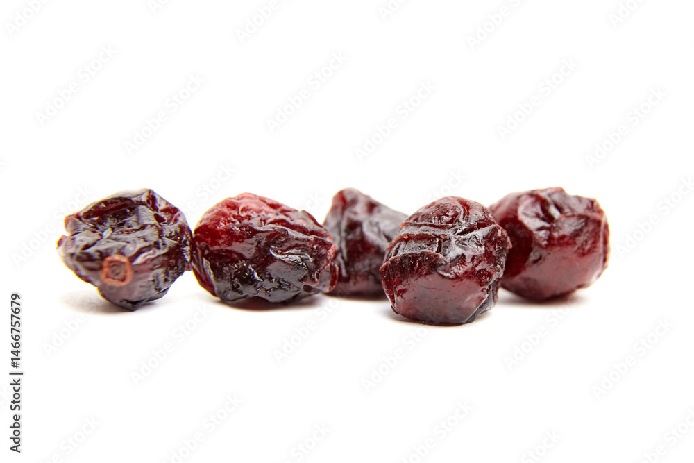 Five dried cranberries arranged in a row on a white surface, showcasing their rich burgundy color, wrinkled texture, and glossy finish in sharp detail Five dried cranberries arranged in a row on a white surface, showcasing their rich burgundy color, wrinkled texture, and glossy finish in sharp detail