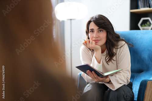 Foto Female therapist listening to client during counseling session in cozy office