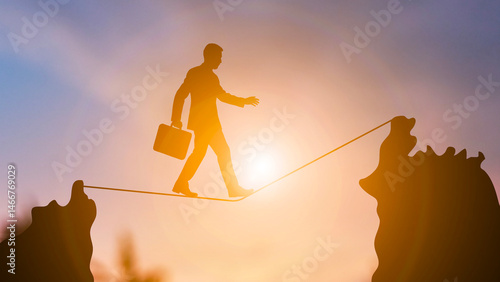 Businessman Walking on a Tightrope at Sunset