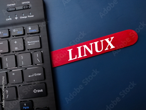 Photography Black keyboard and ice cream stick with the word LINUX on a blue background