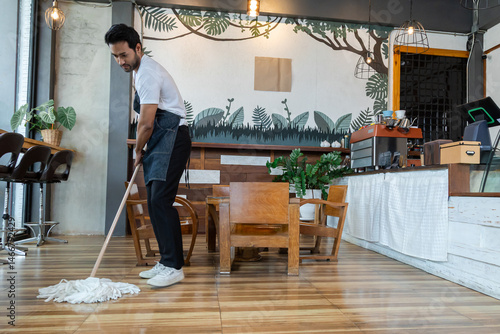 Indian male employee sit and resting after a long day at work. Small business owner coffee shop tired after mopping the floor, waitres secretly fell asleep after working hard. Restaurant owner concept