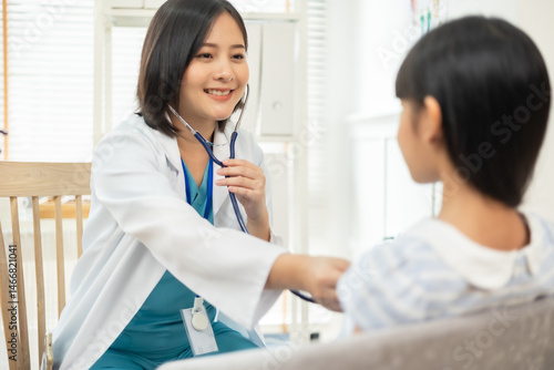 Wallpaper Mural Asian female doctor smiling while examining a young girl, .Healthcare worker checking the health of a patient girl. Torontodigital.ca