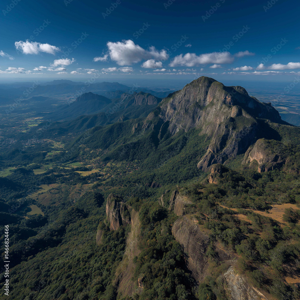 Fototapeta premium Majestic mountain range aerial view lush green forests vibrant blue sky dramatic rock formations
