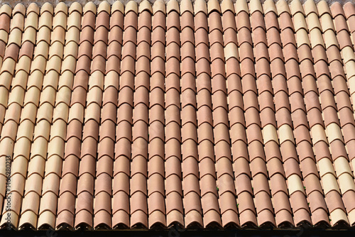 Obraz na płótnie A close-up of a roof covered with rows of red and beige barrel tiles w salonie