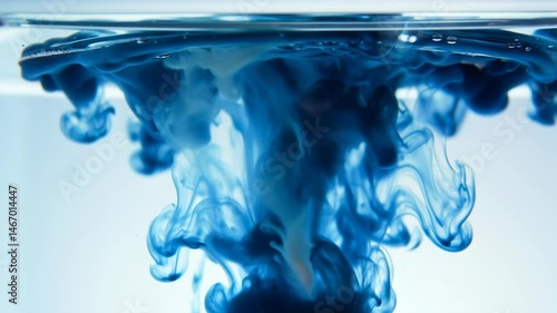 Blue ink swirling in water creating artistic patterns in triptych format