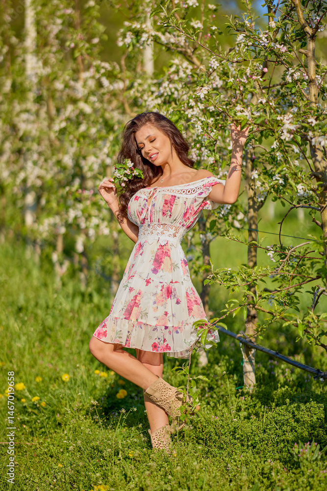Full body portrait of a beautiful woman in a dress in a blooming apple orchard on a sunny spring day Full body portrait of a beautiful woman in a dress in a blooming apple orchard on a sunny spring day