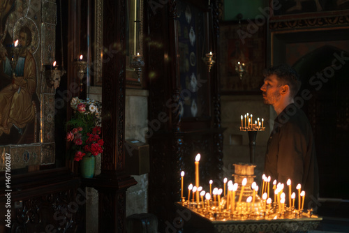Photos Modern Orthodox Christian man praying and lighting candles in a monumental Georgian church