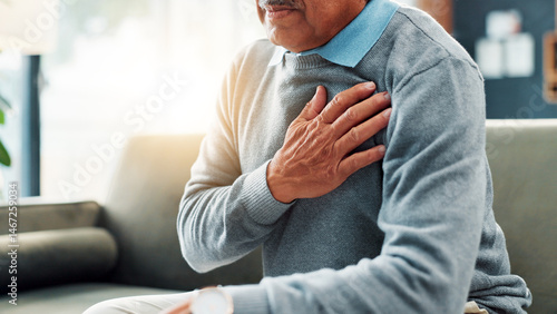 Fotografie Heart attack, hand and senior man in home, sick and emergency for pensioner, strain and high blood pressure