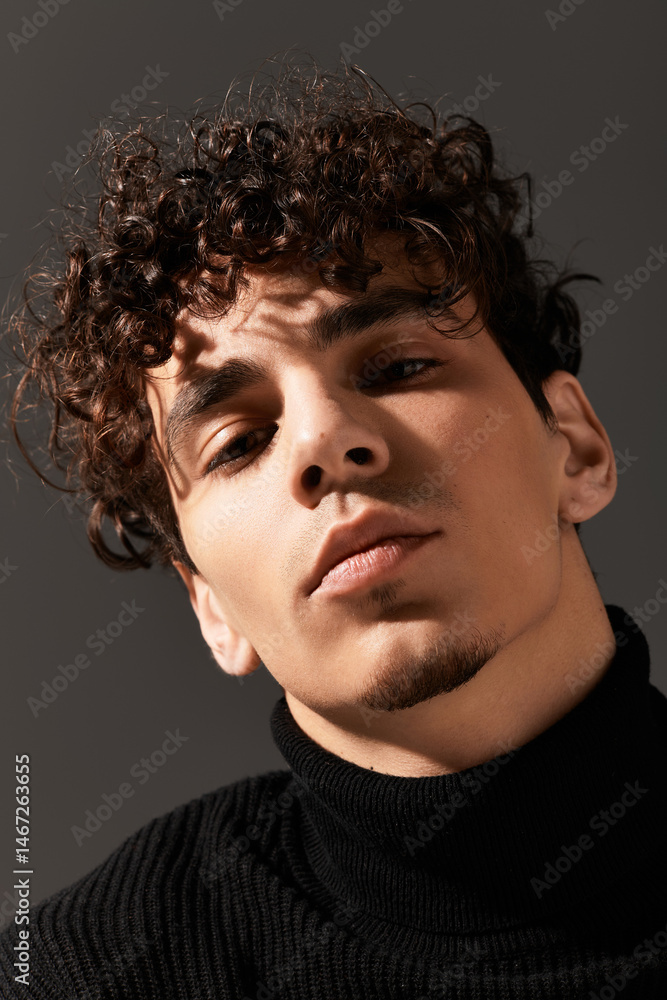 Young stylish man showcasing charm in a modern indoor setting with dramatic lighting Young stylish man showcasing charm in a modern indoor setting with dramatic lighting