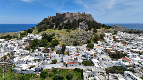 Aerial drone photo of stunning traditional village and medieval archaeological site of Acropolis of Lindos overlooking main beach and Saint Paul's bay, Rhodos island, Dodecanese, Greece