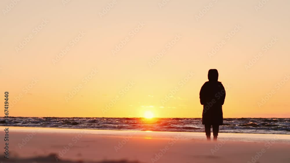 Warm hues, golden sunset reflect on wet shoreline as lone person gazes silently Warm hues, golden sunset reflect on wet shoreline as lone person gazes silently