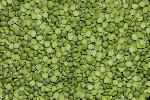 Dried split green peas in a pile on white background