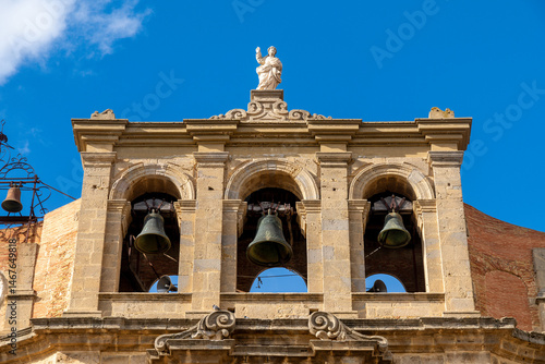 Bell tower of cathedral with statue and arches in Niscemi