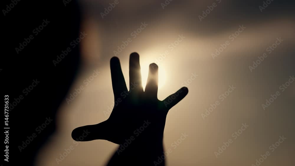 Hand reaching out outdoor sunrise scene. Sunlight streaming through hand. Inspirational moment sunrise outdoors. Hand extended towards sunrise. Scenic view. Hand reaching for new beginnings at sunrise Hand reaching out outdoor sunrise scene. Sunlight streaming through hand. Inspirational moment sunrise outdoors. Hand extended towards sunrise. Scenic view. Hand reaching for new beginnings at sunrise