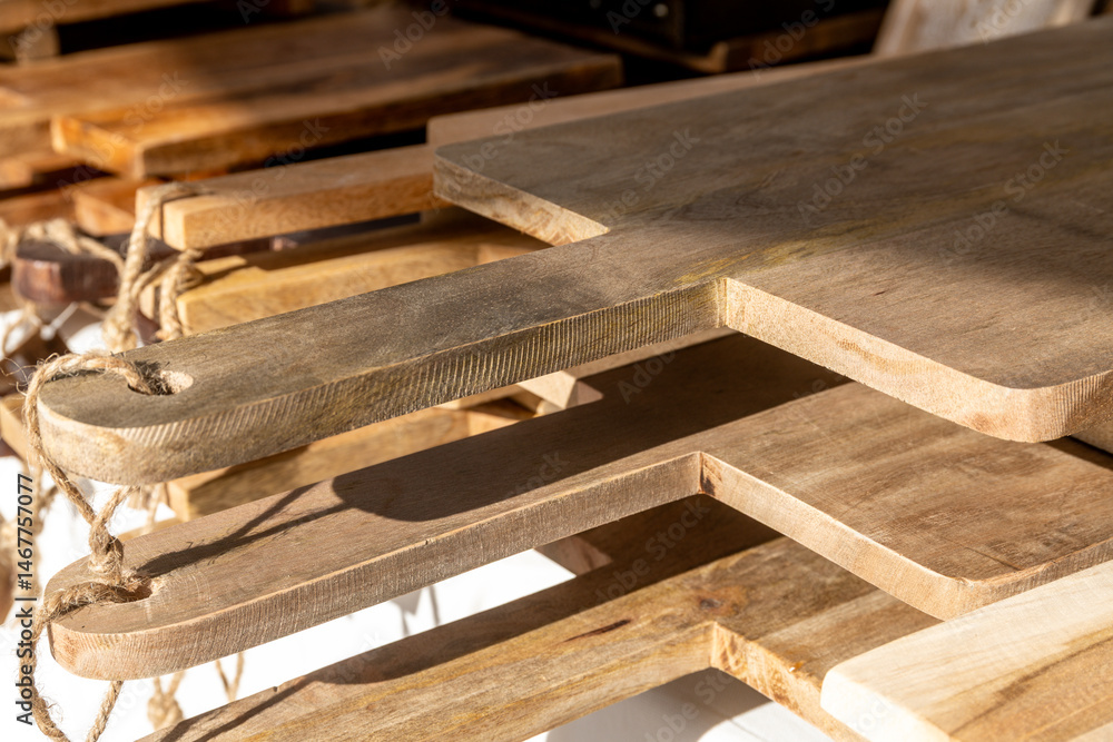 Stacked wooden cutting boards with rope handles Stacked wooden cutting boards with rope handles