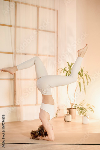 Handstand pose held with still focus in serene space, two woman demonstrates body control, focus flows from strength to silence, focus-driven moment ideal for wellness visuals mindful yoga practice