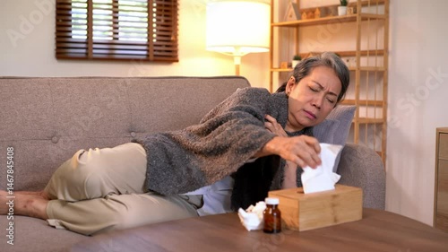 Video 4K Resolution of Senior elderly patient sneezing coughing and pain, flu or sickness with cold or illness in living room