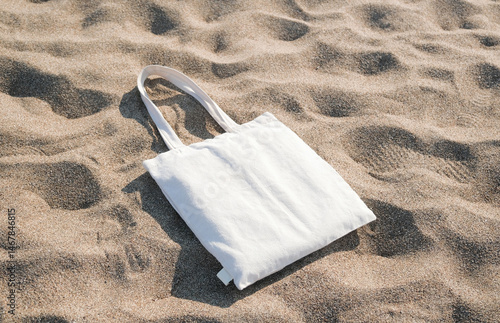White cotton or mesh bag on beach sand background