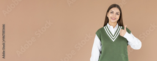 Saying yes. Smiling positive woman, showing thumb up to like and approve, praise good thing, recommending product, brown background