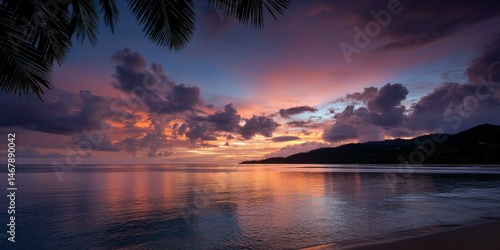 Beautiful sunset over calm ocean with clouds and silhouette of hills
