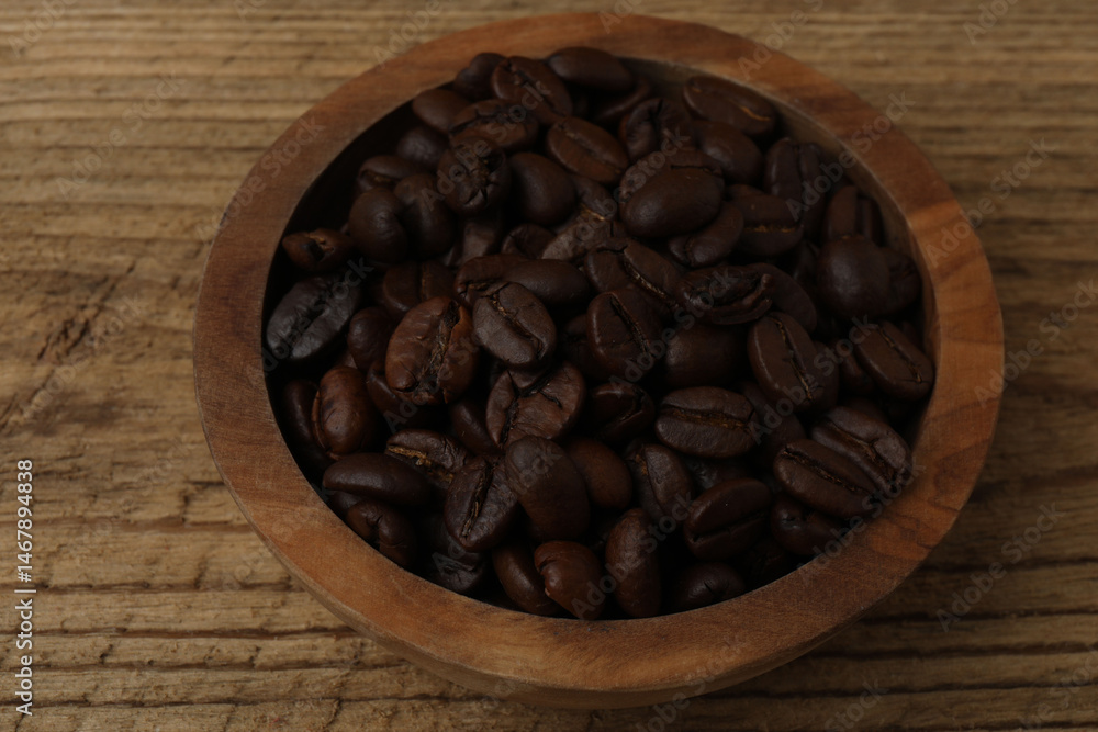 Fototapeta premium Hot coffee in a white coffee cup and many coffee beans scattered around 