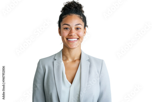 A smiling woman with curly hair in a bun wearing a blazer and a light colored shirt