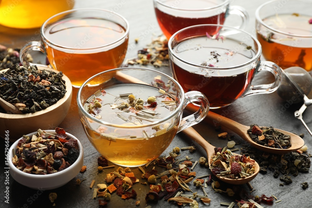 Fototapeta premium Different herbal teas and dry leaves on black table, closeup