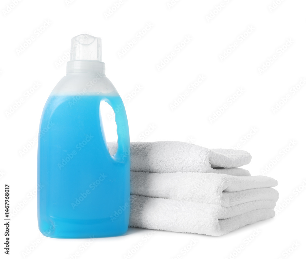 Bottle of fabric softener and towels isolated on white Bottle of fabric softener and towels isolated on white