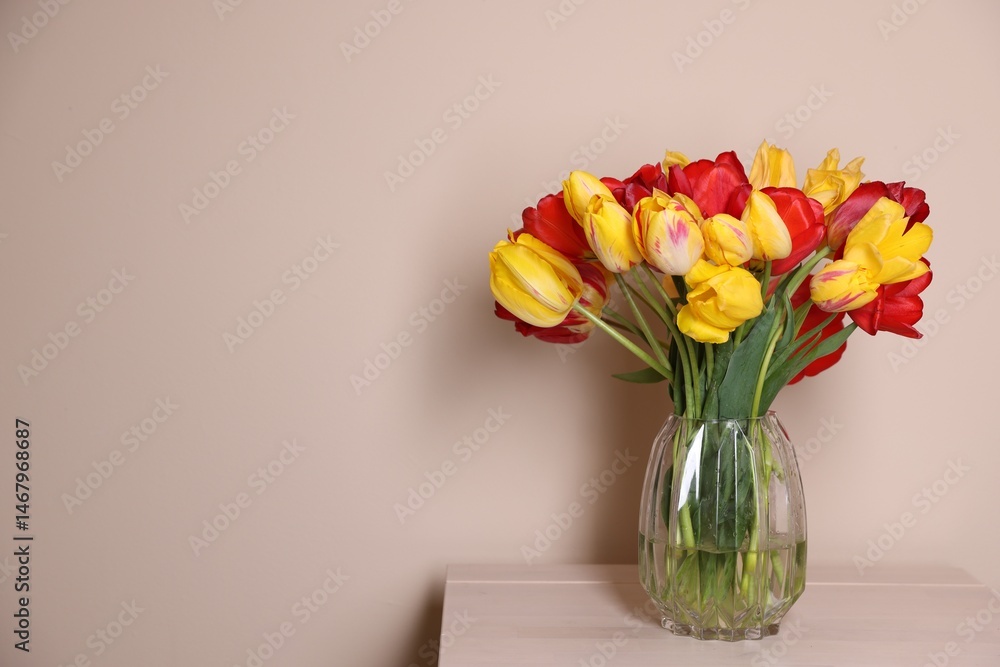 Fototapeta premium Bouquet of beautiful tulips on table against beige background. Space for text