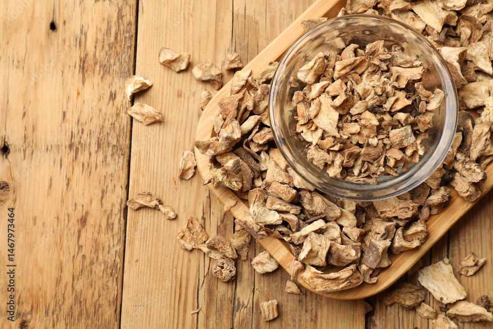 Pieces of dry chicory roots in bowl on wooden table, top view. Space for text Pieces of dry chicory roots in bowl on wooden table, top view. Space for text