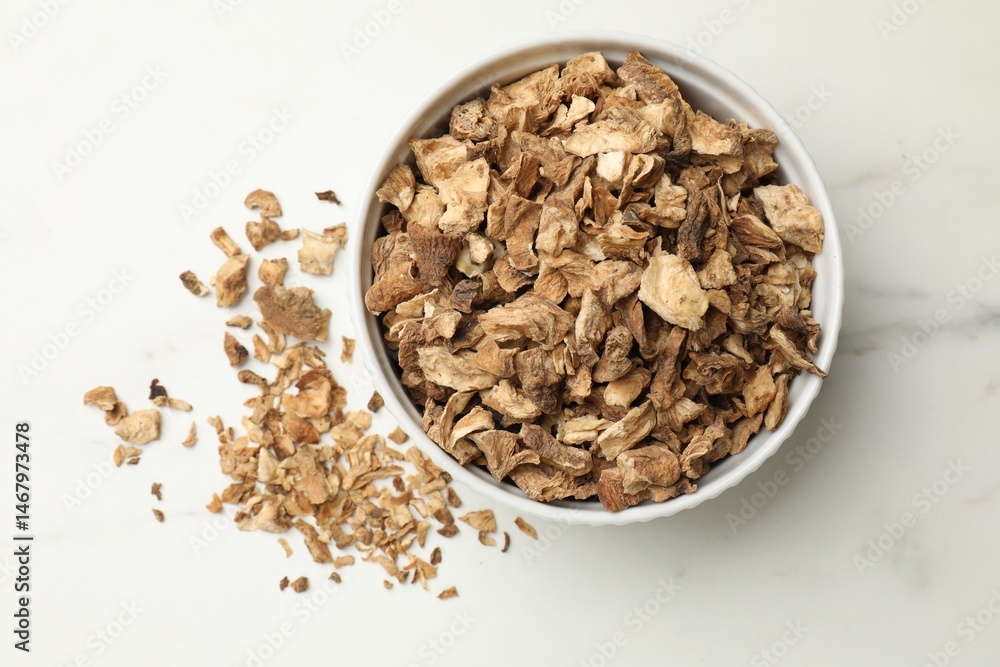 Pieces of dry chicory roots in bowl on white table, top view Pieces of dry chicory roots in bowl on white table, top view