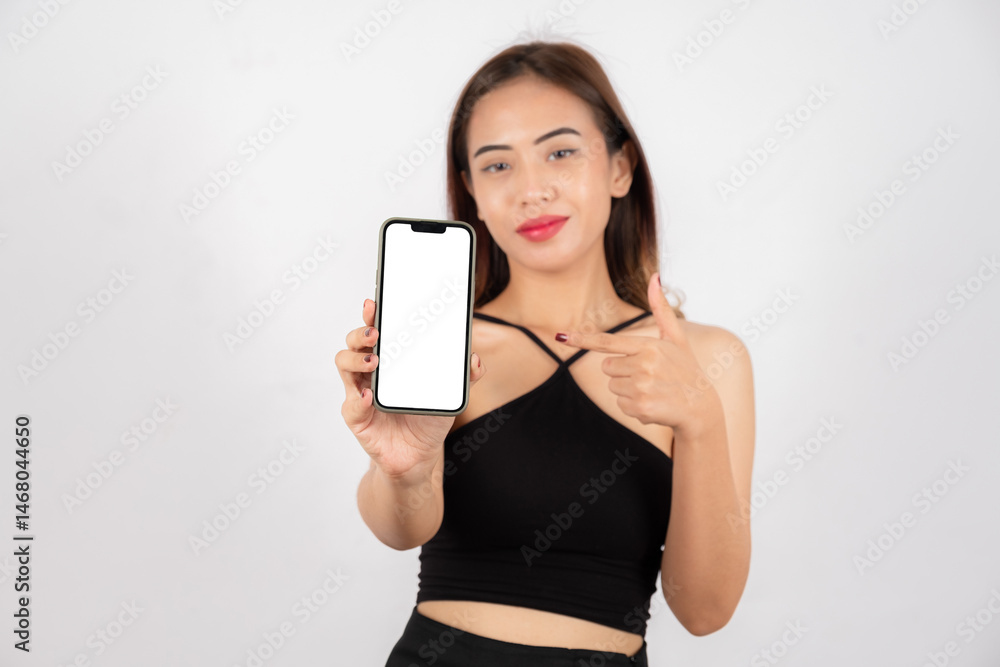 Happy woman showing and pointing at smartphone with blank screen, ready for app or website mockup Happy woman showing and pointing at smartphone with blank screen, ready for app or website mockup