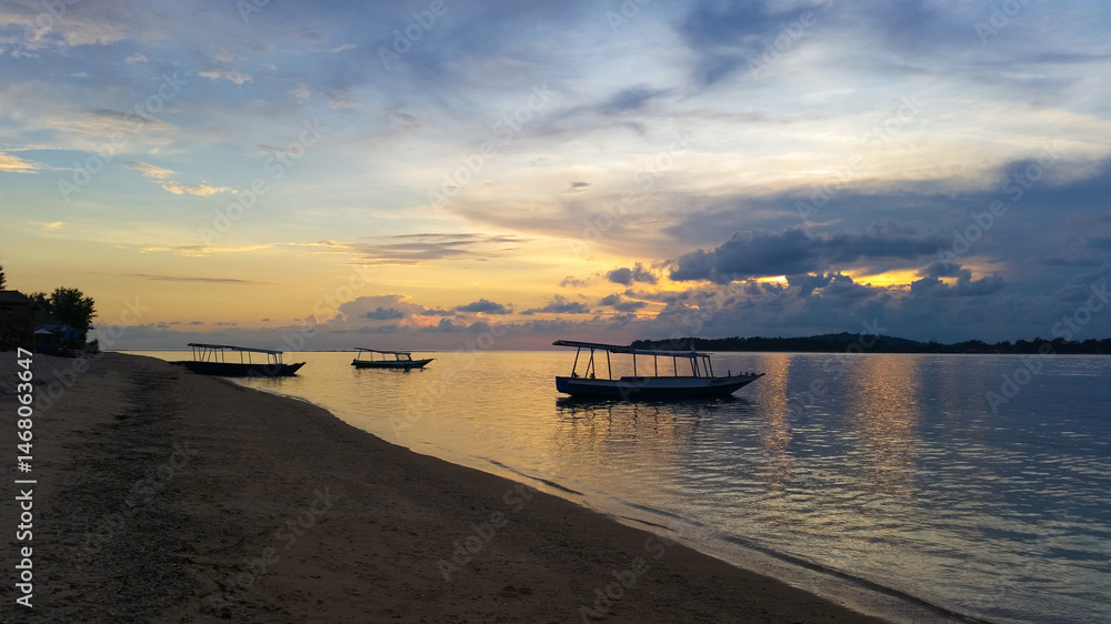 Fototapeta premium beautiful dramatic landscape of sunset on sea beach with silhouette of boat