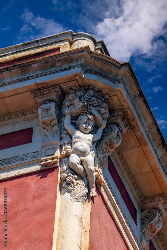 Obraz premium Angel sculpture on the corner of an old building facade in Catania, Sicily, Italy, in daylight
