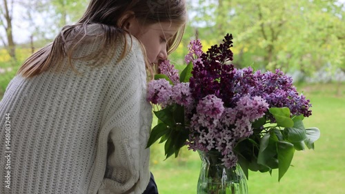 Girl smelling lilac flowers. Video 4k