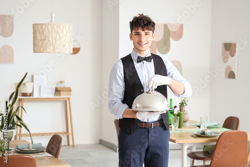 Male waiter with cloche in ...