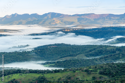Landscape of the valley, seen from the top of the Serra da Moeda, partially covered by clouds, during the fall dawn. Brumadinho, Brazil
