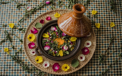 Marrakech, Morocco, Moroccan tagine with floral garnish on patterned surface