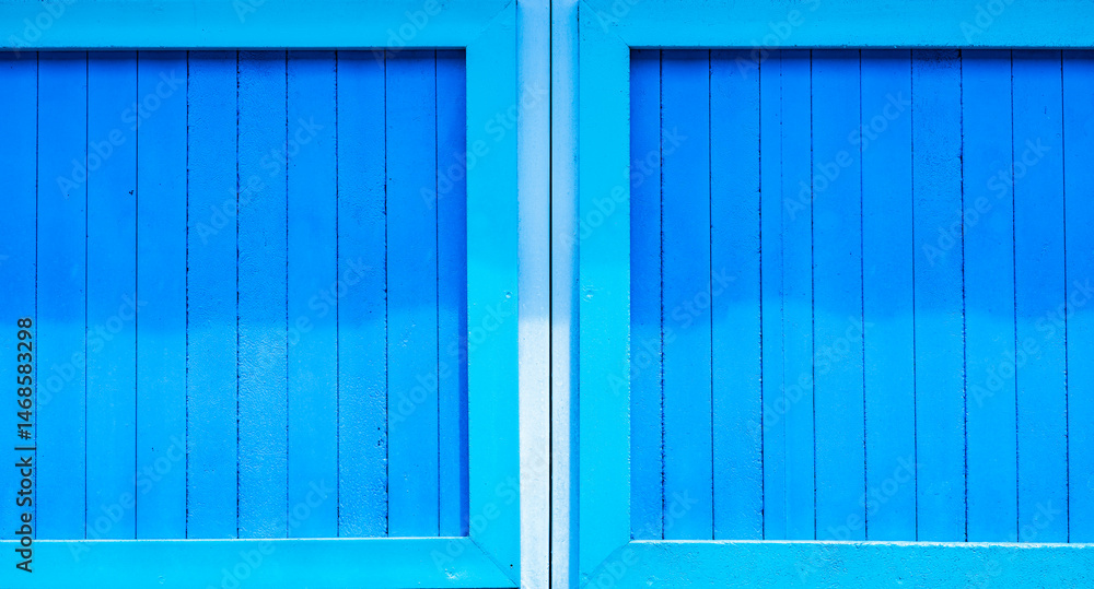 Puerta de madera azul con diseño simétrico, estilo arquitectónico tradicional y textura vibrante Puerta de madera azul con diseño simétrico, estilo arquitectónico tradicional y textura vibrante