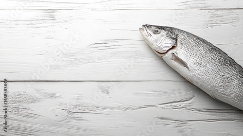 Fresh, whole salmon resting atop a light wood surface.