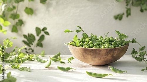 Fresh peas in a wooden bowl, surrounded by greenery