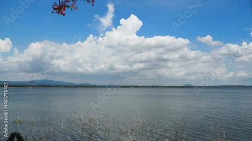 Timelapse of white clouds, blue sky, a quiet seaside or waterfront.