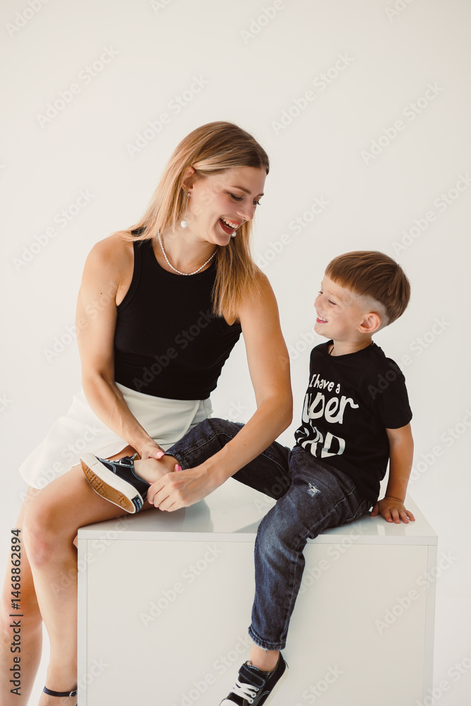 Mom and 4 year old son smiling and hugging on a white background. Warm relationship between mom and son. Concept of family relationships between mom and son.