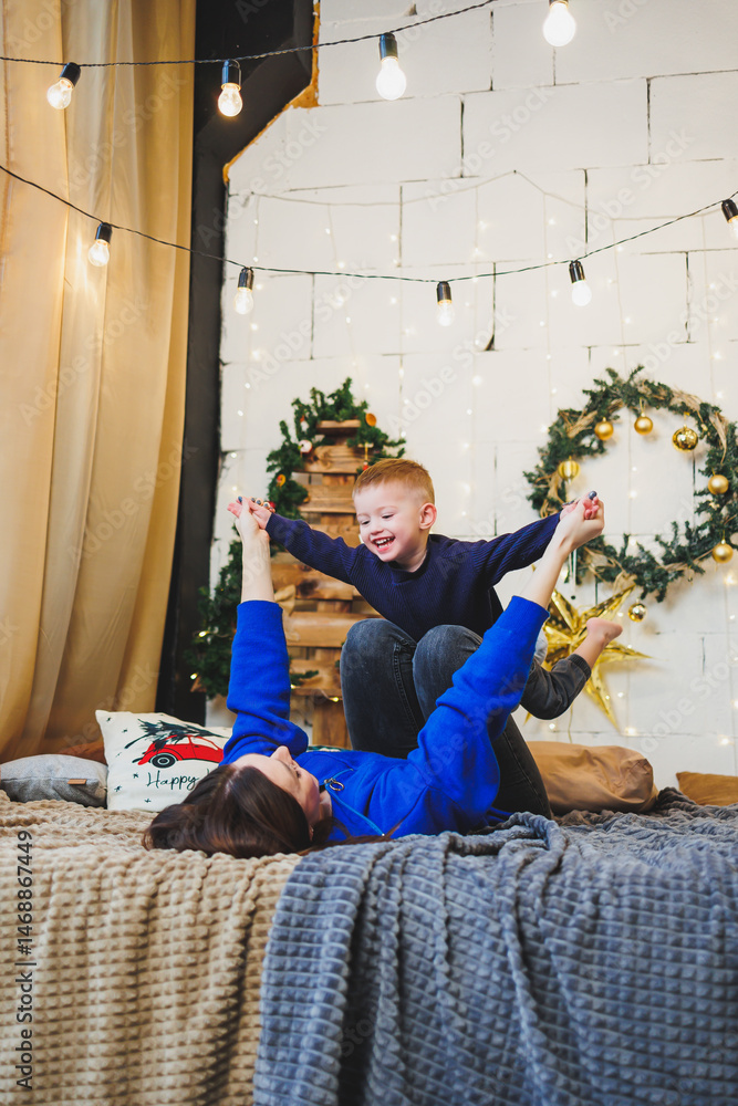 Mom spends time with her son on New Year's Eve at home. Holiday games of mom with son at home. Cheerful childhood.