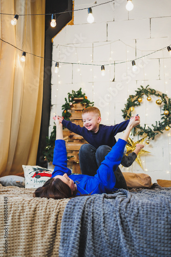 Obraz na płótnie Mom spends time with her son on New Year's Eve at home. Holiday games of mom with son at home. Cheerful childhood. w salonie