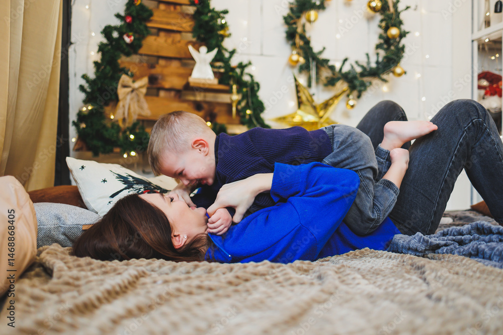 Mom spends time with her son on New Year's Eve at home. Holiday games of mom with son at home. Cheerful childhood.