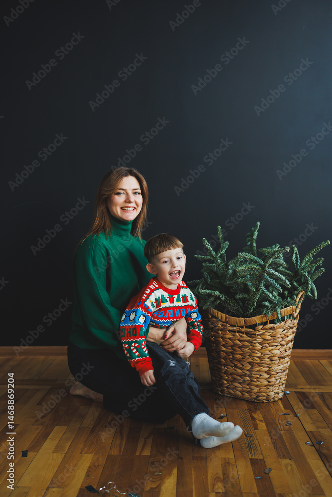 Mom spends time with her son on New Year's Eve at home. Holiday games of mom with son at home. Cheerful childhood.